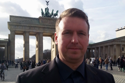 Bild des Immobilienmaklers John Knoch vor dem Brandenburger Tor in Berlin